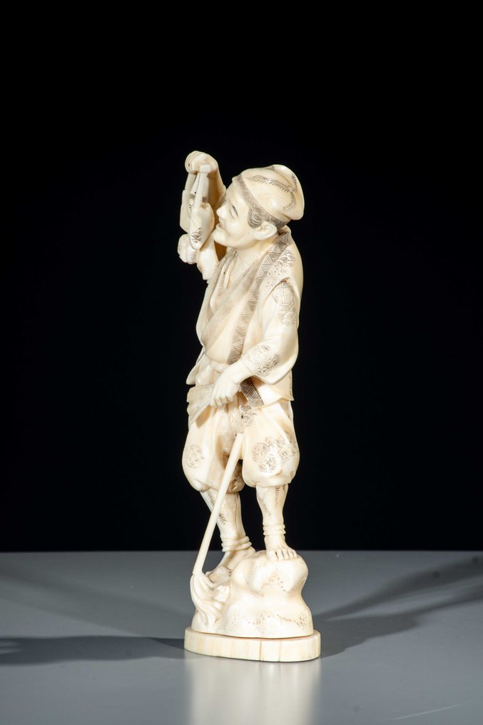 Marine ivory - Signed Gyokushi 玉之 - A marine ivory okimono of a man with a puppet. - Meiji period (19th century) #2.1