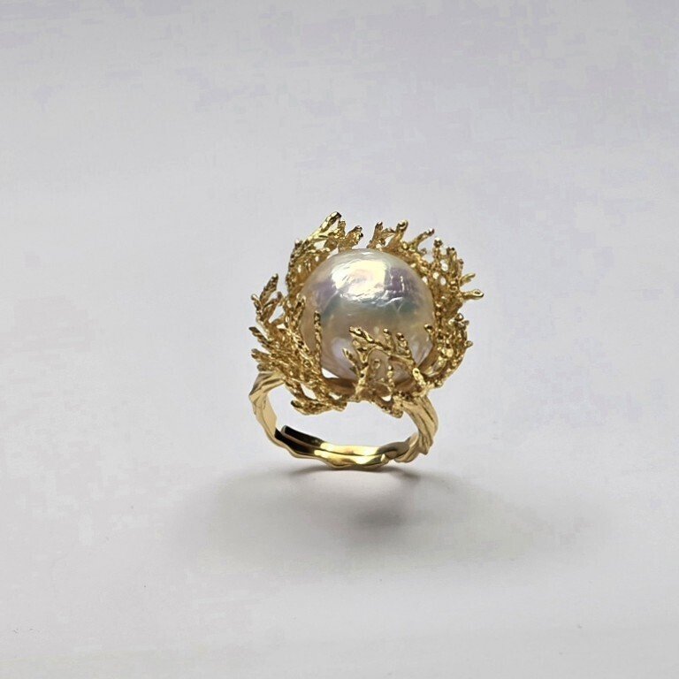 Anello modello "cestino corallo" con gambo rigato, ondulato in argento dorato 925‰, con perla d' acquadolce bianca barocca regolare con nucleo ø 15 mm, ingombro ø 24 mm, regolabile da 15 a 20.- 13.5 g - (1) #2.1