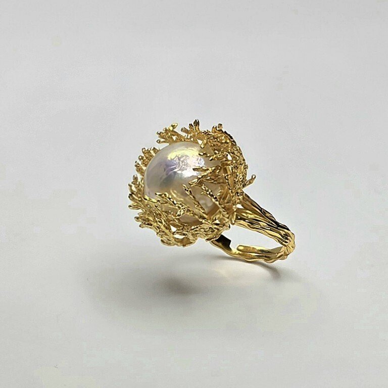 Anello modello "cestino corallo" con gambo rigato, ondulato in argento dorato 925‰, con perla d' acquadolce bianca barocca regolare con nucleo ø 15 mm, ingombro ø 24 mm, regolabile da 15 a 20.- 13.5 g - (1) #1.0