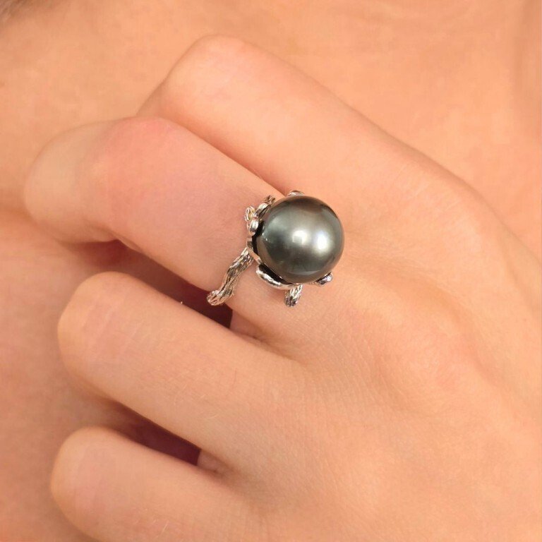Ring with a ridged and wavy shank, with a flower-shaped setting in 925‰ silver. Tahitian pearl semi-round ø 11.5 mm, adjustable size from 12 to 20.- 6.8 g - (1) #1.0