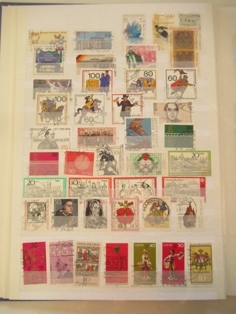 世界  - 一位考官仔细观察，邮票收藏在多个相册中。 #4.3