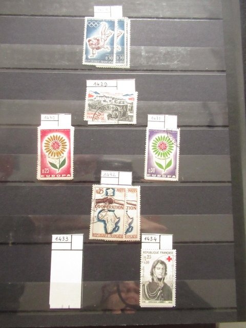 法国  - 一位考官仔细观察，邮票收藏在多个相册中。 #2.1