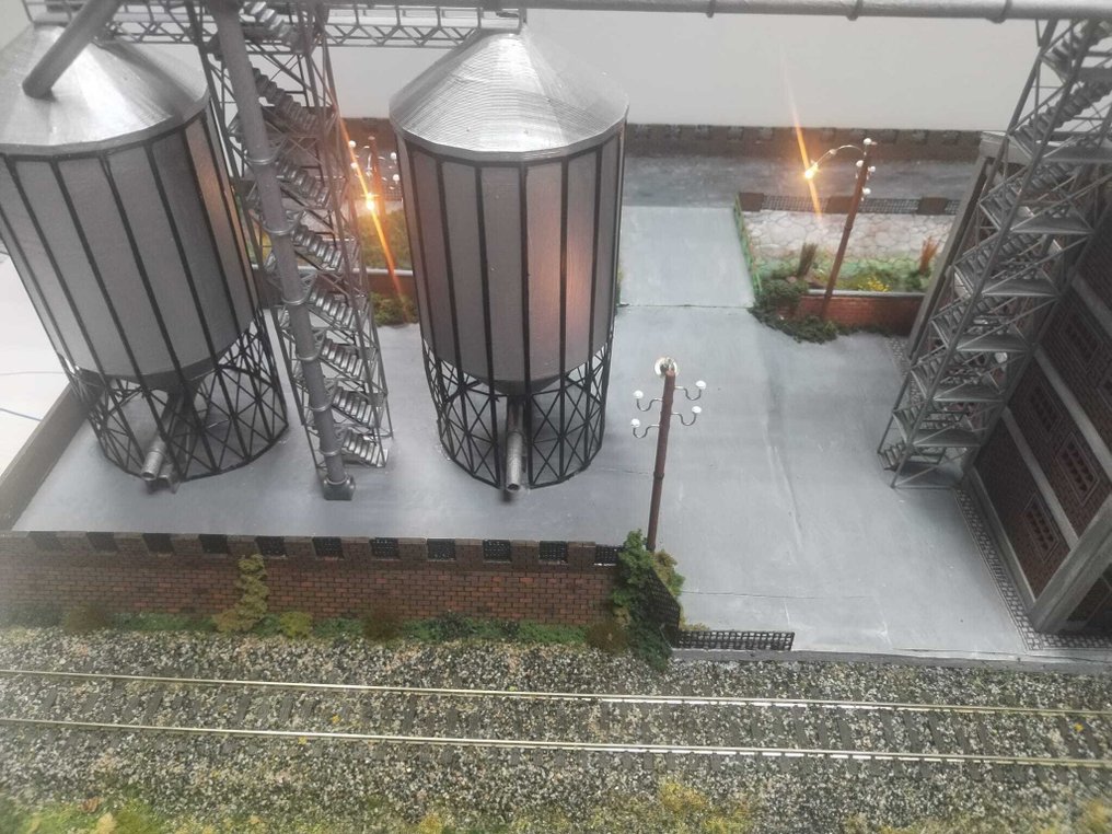 dioramemachete.ro H0 - 模型火車風景 (1) - 手工制作的工业场景模型，展示两个高架小麦筒仓及通道桥。 #4.3