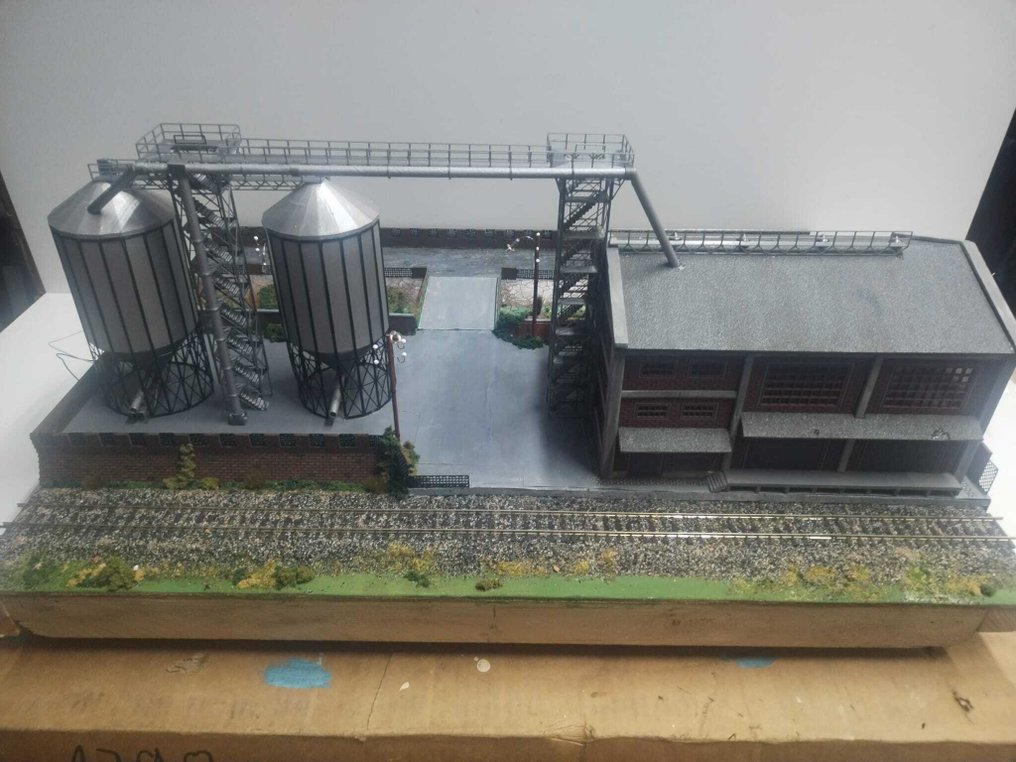 dioramemachete.ro H0 - 模型火車風景 (1) - 手工制作的工业场景模型，展示两个高架小麦筒仓及通道桥。 #1.0
