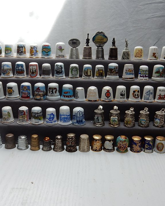 Large wooden thimble display case and various thimbles including glass,  souviner, metal etc.